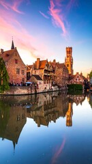 Obraz premium Quaint European townscape, brick buildings reflecting in calm canal at sunset