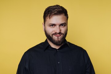 Obraz premium Portrait of a confident young man against a vibrant yellow background, showcasing personality and charm in a modern setting