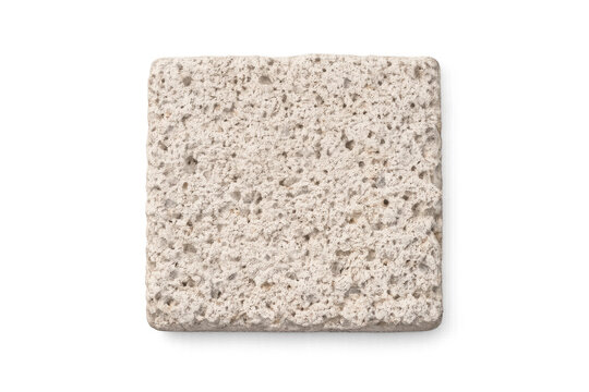 Rough textured porous pumice stone block isolated on white background with subtle shadow