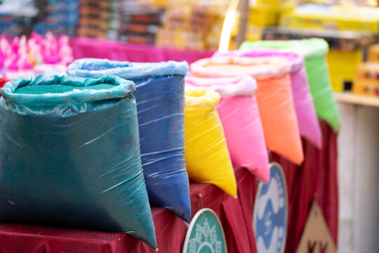 Vibrant packets of colored gulal powder displayed at a market stall for the Indian festival of colors Holi, symbolizing celebration, joy, and traditional spring festivities.