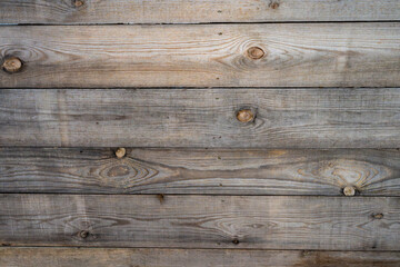 Naklejka premium the textured surface of horizontally arranged, weathered wooden planks with visible grain and prominent knots.