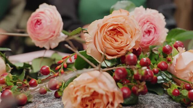 Floral display details. Closeup of flowers and berries. Intricate arrangement with vibrant roses and berries. Artisan styled floral composition with natural lighting effects and textures