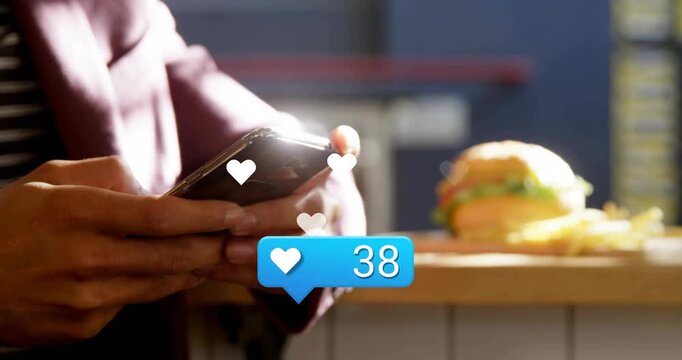 Man holding smartphone at cafe, incoming alert causing hearts and counter hitting 77 for marketing