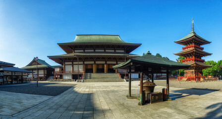 Obraz premium view of Naritasan temple with red pagoda and blue sky in Naritasan Shinshoji temple at Chiba Prefecture.