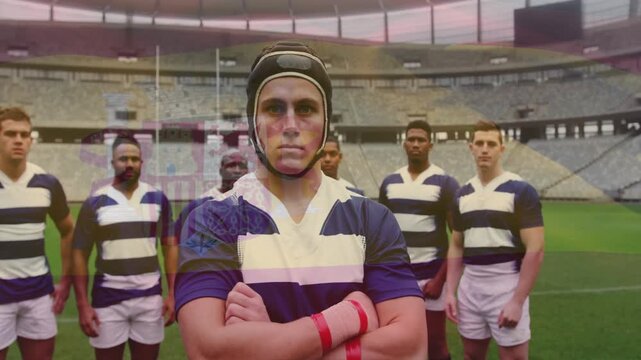 Camera pulling back central rugby captain standing arms crossed, wearing scrum cap showing unity