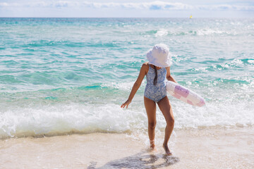 Little girl playing on sandy beach in Sardinia enjoying summer seaside vacation by the turquoise Mediterranean Sea © anatoliycherkas