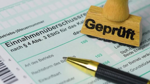 Ein Formular zur Einkommensteuer wird vom Finanzamt mit einem Stempel markiert - FOTOMONTAGE