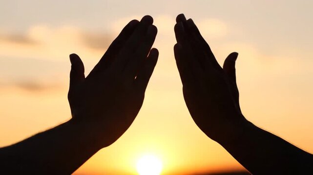Hands Forming Triangle Shape at Sunset.