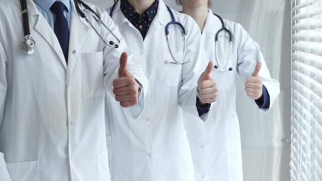 Medical team showing thumbs up gestures, symbolizing healthcare success, collaboration, good results, excellent medical service, and professional doctor approval