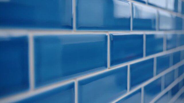 Shiny blue subway tiles with white grout on a wall
