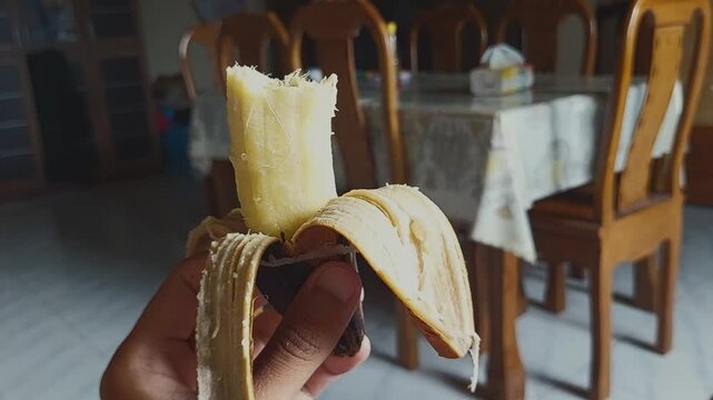 hand holding a piece of rebua banana that has been bitten 