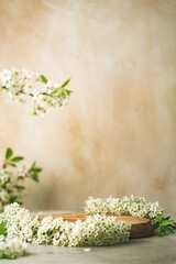 Geometric empty podium wooden platform stand for product presentation and spring flowering tree...