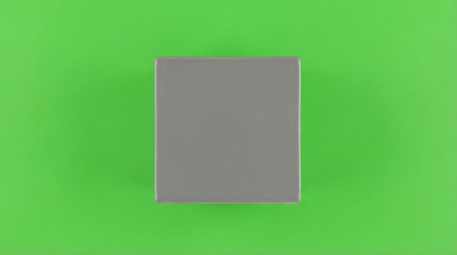 Blank grey rectangular box on a vibrant green background, isolated for product presentation or design.