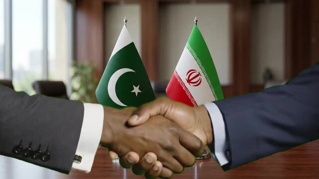 Diplomatic handshake footage symbolizing agreement between pakistan and iran officials over a polished conference table