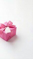 Fototapeta premium Pink gift box with a pink ribbon and a tooth shaped tag on a white background, dental health present, festive clinic surprise, medical celebration, National Dentist's Day.