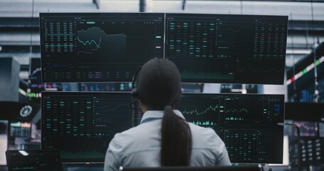 Professional Asian Woman in Business Attire Manages Investments in Futuristic Exchange Center....