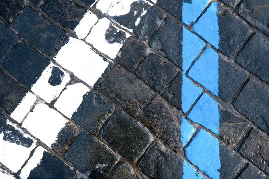 Road markings. Detailed image showing the contrast between dark gray concrete and bright blue and white road paint.