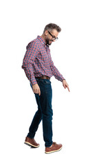 Side view of happy man walking and pointing down