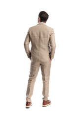 Naklejka premium Rear view of elegant man standing with hands in pockets