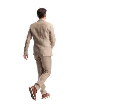 Back view of smart man walking away in suit