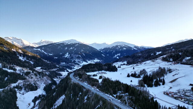 Aerial view of Brenner Pass, Austria with alpine highway bridge, snowy mountains and winter valley landscape. Scenic transport route through the Austrian Alps.
