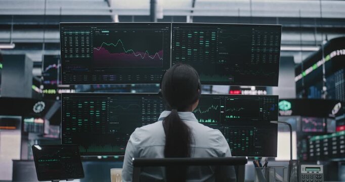 Professional Asian Woman in Business Attire Manages Investments in Futuristic Exchange Center. Concept of Innovative Digital Workspace and Big Data Visualization in Modern Financial Industry.