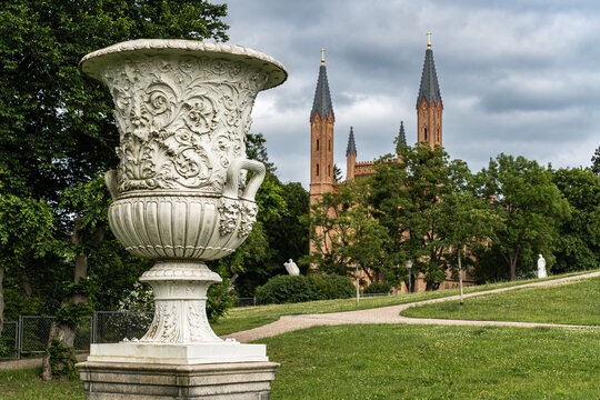 View from the Palace Park in Neustrelitz towards the Palace Church, Mecklenburg-Western Pomerania, Germany, with a large decorative vase in the foreground.