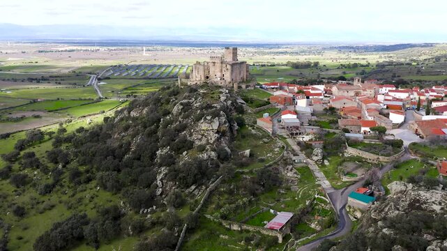Aerial view of Belv&iacute;s de Monroy Castle, a medieval hilltop fortress ruins overlooking rural Caceres landscape, historic defensive architecture surrounded by countryside and open skies.