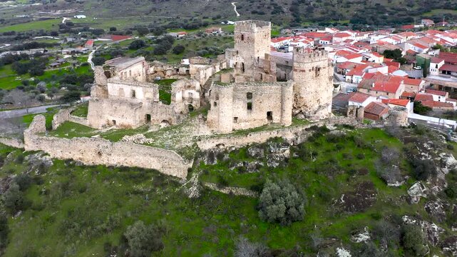 Aerial view of Belv&iacute;s de Monroy Castle, a medieval hilltop fortress ruins overlooking rural Caceres landscape, historic defensive architecture surrounded by countryside and open skies.