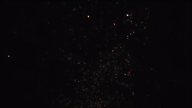 A dark scene speckled with glowing embers of varying sizes and brightness