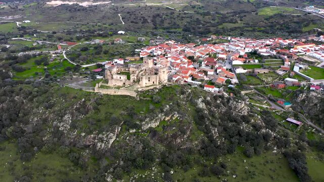Aerial view of Belv&iacute;s de Monroy Castle, a medieval hilltop fortress ruins overlooking rural Caceres landscape, historic defensive architecture surrounded by countryside and open skies.