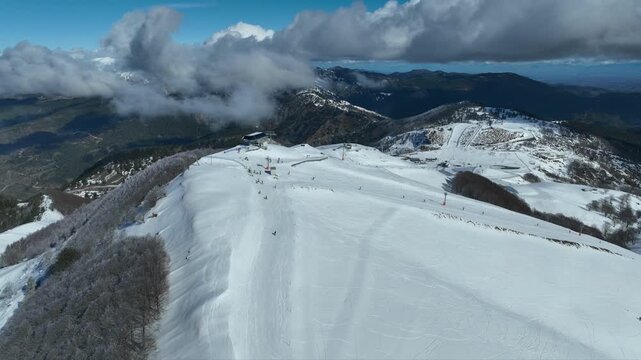 Aerial drone cinematic video of recently renovated snow center of Anilio Perched on the top of Pindus, with the comparative advantage of easy and direct access via the Egnatia Motorway, covered in sno