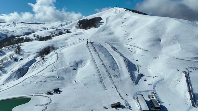 Aerial drone cinematic video of recently renovated snow center of Anilio Perched on the top of Pindus, with the comparative advantage of easy and direct access via the Egnatia Motorway, covered in sno
