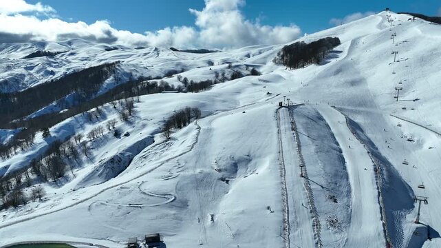 Aerial drone cinematic video of recently renovated snow center of Anilio Perched on the top of Pindus, with the comparative advantage of easy and direct access via the Egnatia Motorway, covered in sno