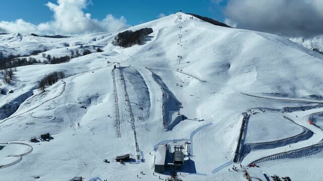 Aerial drone cinematic video of recently renovated snow center of Anilio Perched on the top of Pindus, with the comparative advantage of easy and direct access via the Egnatia Motorway, covered in sno