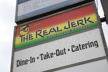 Naklejka premium pylon sign for The Real Jerk Restaurant, a Caribbean restaurant, located at 842 Gerrard St E, Toronto
