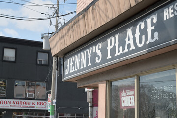 Naklejka premium exterior building facade and sign of Jenny's Place, a bar, located at 1338 Gerrard St E, Toronto