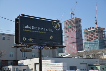 Obraz premium road side pylon billboard sign (with Betty ad) inside the Central Fairbank Lumber complex at 2296 Gerrard St E, Toronto (with view of Main Square redevelopment behind)