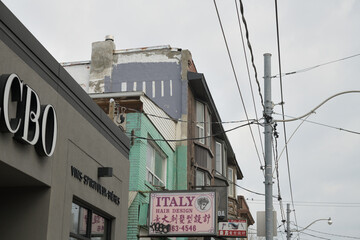 Naklejka premium old buildings near the intersection of Gerrard St E and Pape Av incl projecting signs for Italy Hair Design at 934 Gerrard St E, Toronto