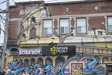 Obraz premium Boba Boy, a bubble tea store, and Chicken Plus, a fast food restaurant, both located at 368 Broadview Av, southwest corner of Gerrard St E, Toronto 