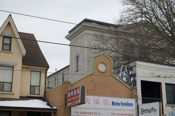 Obraz premium eclectic contrast of architectural styles including sign of Metro Furniture, a furniture store, located at 715 Gerrard St E, Toronto