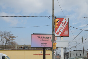 Naklejka premium looking east on Gerrard St E from about Greenwood Av to signs (Metro Mart, and Raven vitamins) and Hoa Nghiem Temple, a Buddhist temple at 1278 Gerrard St E, Toronto