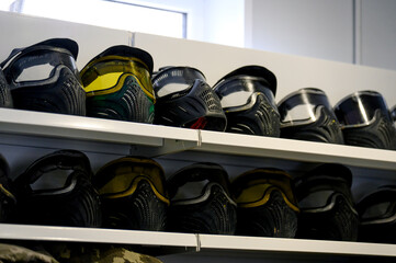 Paintball masks arranged on shelves in indoor storage facility