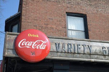 Naklejka premium vintage remnants of Jack's Variety & Grocery, metal block letters and a Coca-Cola button sign on the exterior of 1999 Gerrard St E, Toronto