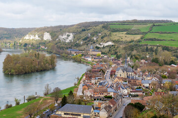 Panoramic townscape of Les Andelys from Chateau Gaillard, spring season with emerging green foliage, river flowing through town, historic architecture highlighting French heritage © Ekaterina Elagina
