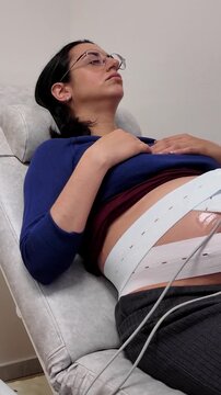 Pregnant woman undergoing cardiotocography fetal monitoring test