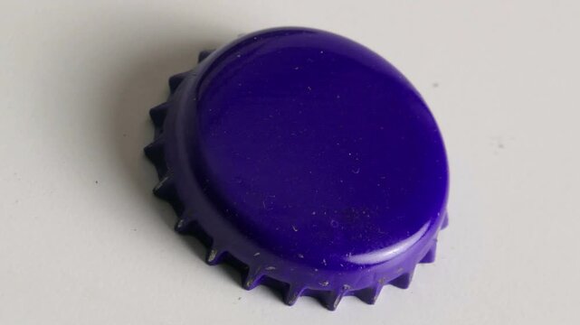 Changing beer bottle-caps in different colors. Shot in time lapse with red, black, gold, purple and white craft beer pry caps.