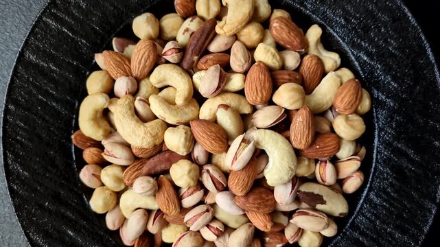 A mix of cashews, pistachios, almonds, brazil nuts, macadamia and hazelnuts as healthy food ingredients. Nuts as a food background for your design