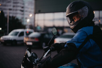 A female motorcyclist riding a motorcycle in the city in the evening