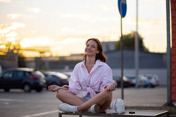 woman meditates on a bench on a city street, a concept of professional burnout and harmony.